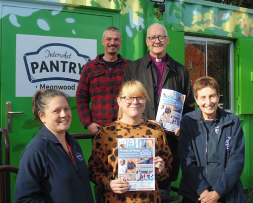 bishop in front of pantry with other people holding pantry papers