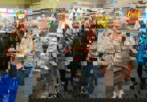 woman in party hats and a cake with 300 candles within a pantry shop