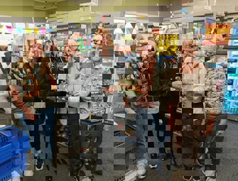 woman in party hats and a cake with 300 candles within a pantry shop