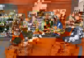 group of people in orange aprons holding food