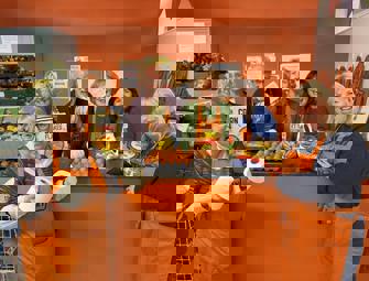 group of people in orange aprons holding food