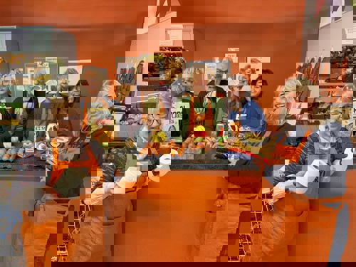 collection of older people in orange aprons against an orange background