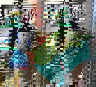 woman holding a basket with large amount of lettuce 