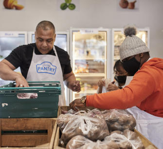 people with black masks sorting through food