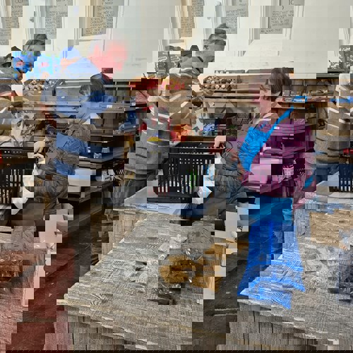 woman at a pantry shop till with man with hands in bag