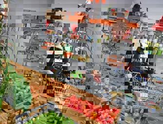 woman holding a basket with vegetables in front 