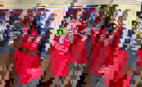 5 people in red aprons holding health sign