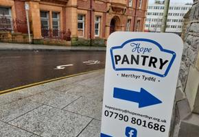 your local pantry sign outside with a blue arrow pointing to the side