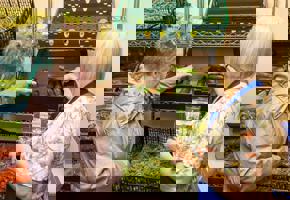 two woman reaching for food 