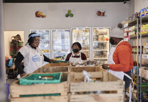 Wooden storage in front of people sorting through food