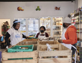 Wooden storage in front of people sorting through food