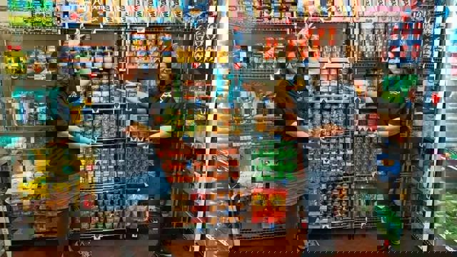 two woman pointing to food on shelves