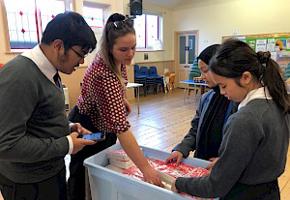Children inn school uniforms inside a hall picking out food