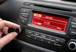 hand on a dial of a car radio