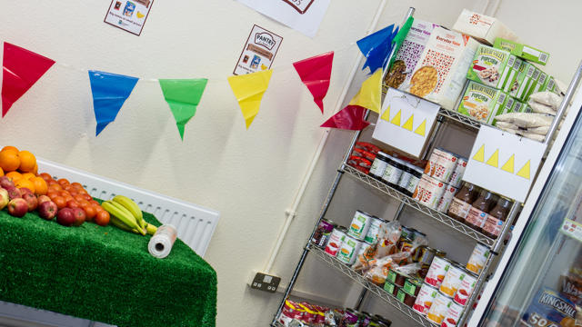 food on a green table inside a pantry with other food on a shelf