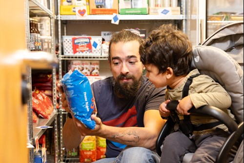 Man With Child In Pushcair Inside A Pantry