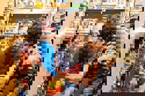 Man With Child In Pushcair Inside A Pantry