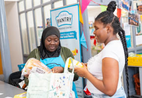Two woman putting bread into a bag