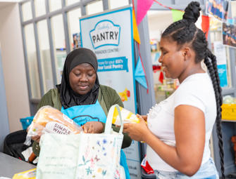 Two woman putting bread into a bag
