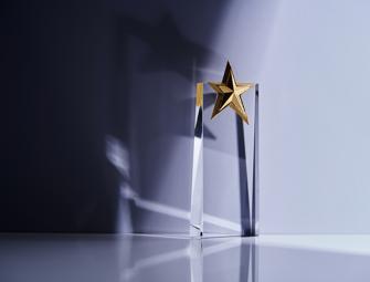 close up of an award trophy made of glass with a star on top