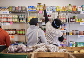 woman reaching to the top of a food shelf