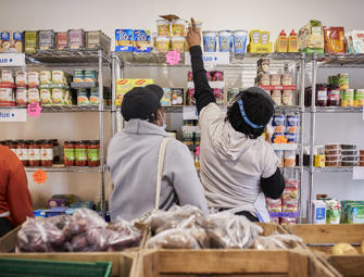 woman reaching to the top of a food shelf