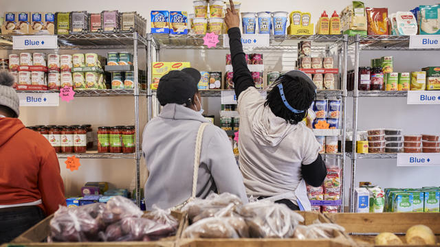 woman reaching to the top of a food shelf