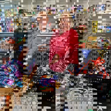two woman standing in front of collection of foods in a pantry