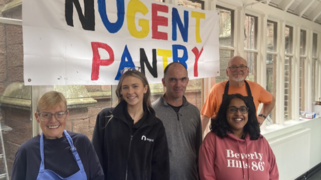 Group in front of Nugent Pantry sign in paint 