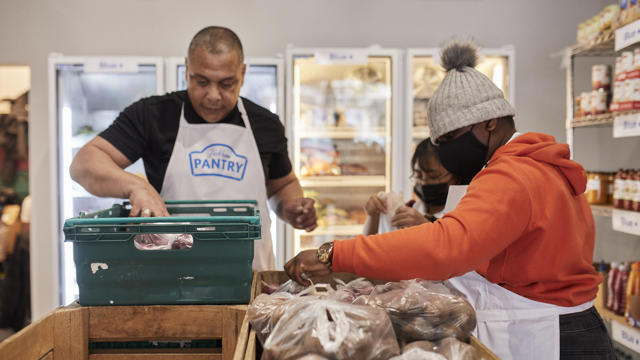 people with black masks sorting through food