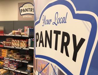 close up of local pantry logo on banner next to food shelves