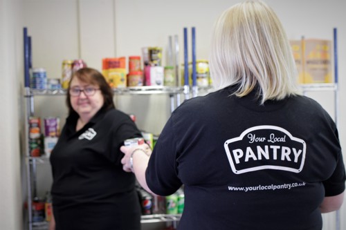 Stockport Pantry team in Pantry polo shirts stocking shelves