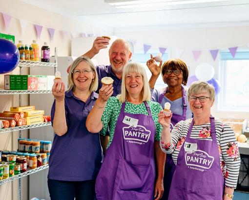 collection of people in purple aprons holding up cupcakes