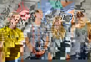 two woman and two men in front of pantry and church action poverty signs