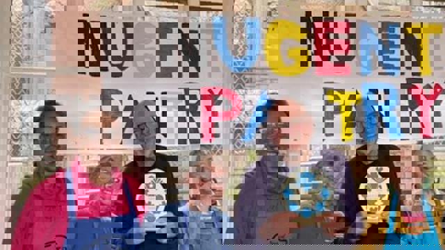 Group in front of Nugent Pantry sign in paint 