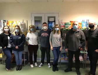 group of people in masks in front of food shelves