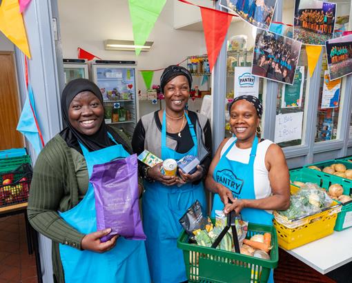 Group of woman holding up food with one holding a basket