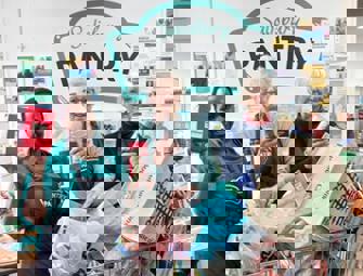 group of woman in front of pantry sign with trolley full of bags